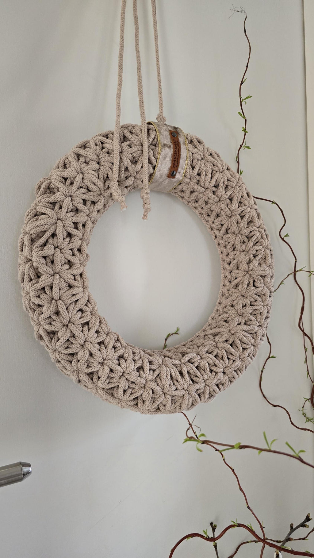Dieser handgefertigte Wandkranz besticht durch sein elegantes Jasmin-Häkelmuster, das ihm eine besonders feine Struktur verleiht. Seine Naturfarben und sein minimalistisches Design machen ihn zu einem perfekten skandinavischen Wohnaccessoire für dein Zuhause.