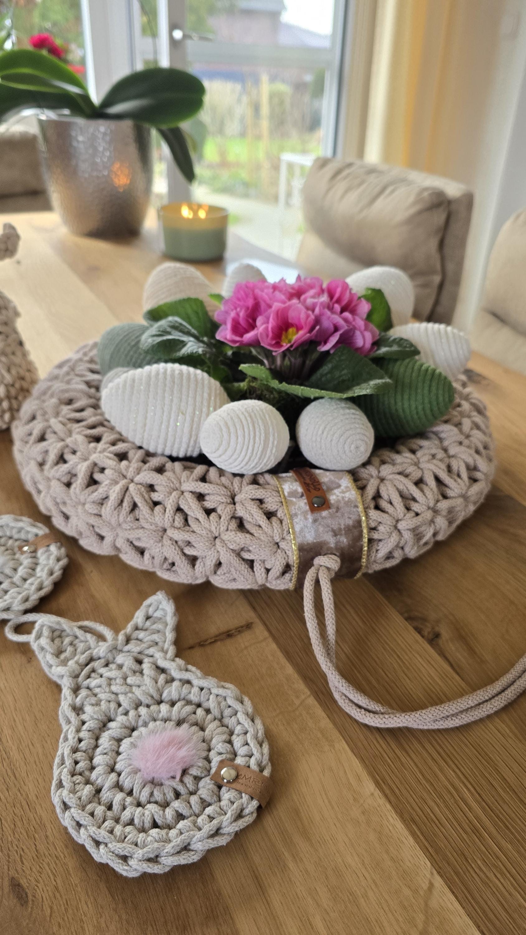 Dieser handgefertigte Wandkranz besticht durch sein elegantes Jasmin-Häkelmuster, das ihm eine besonders feine Struktur verleiht. Seine Naturfarben und sein minimalistisches Design machen ihn zu einem perfekten skandinavischen Wohnaccessoire für dein Zuhause.