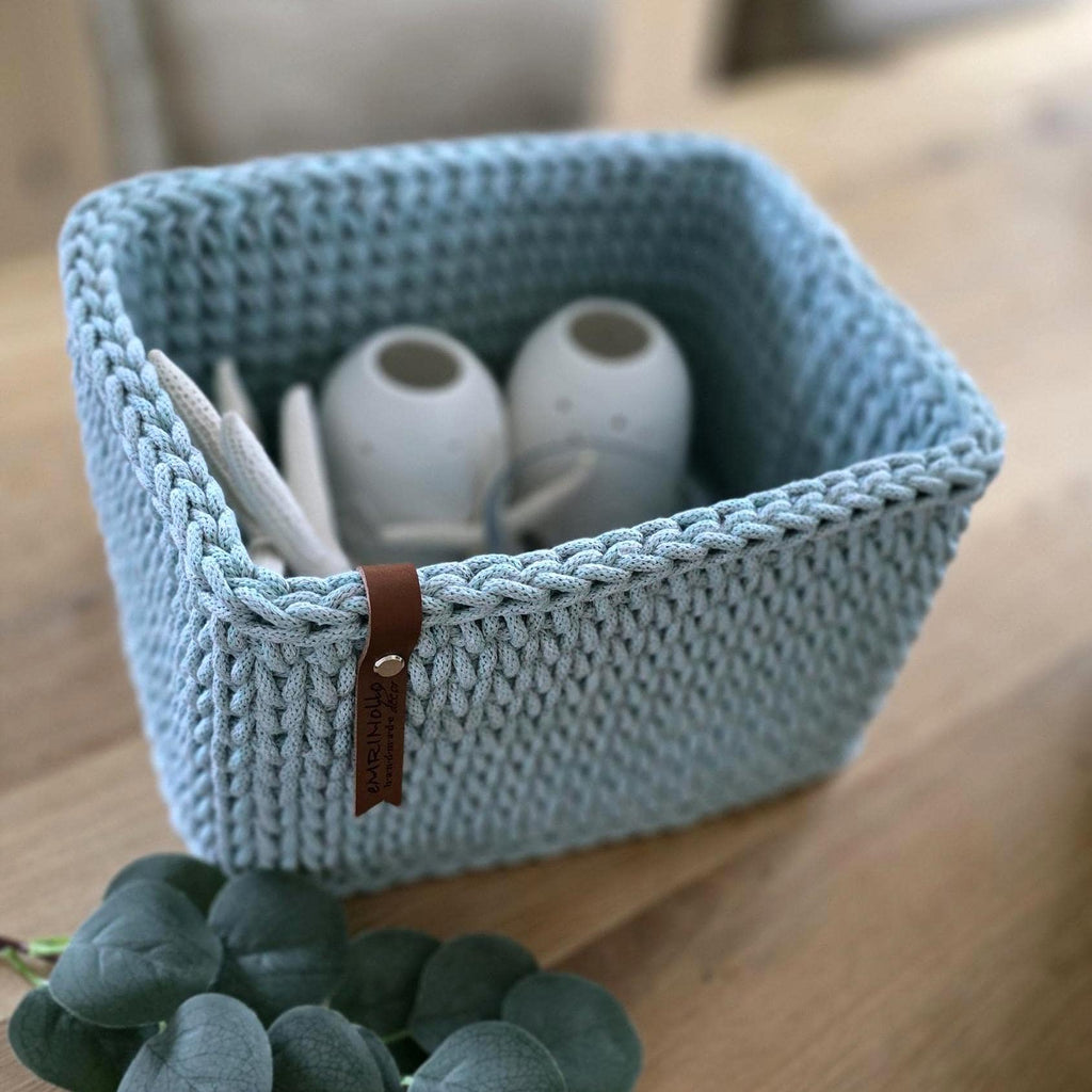 Korb im Regal mit Wohnaccessoires, sanftes Tageslicht, minimalistisches Interior.