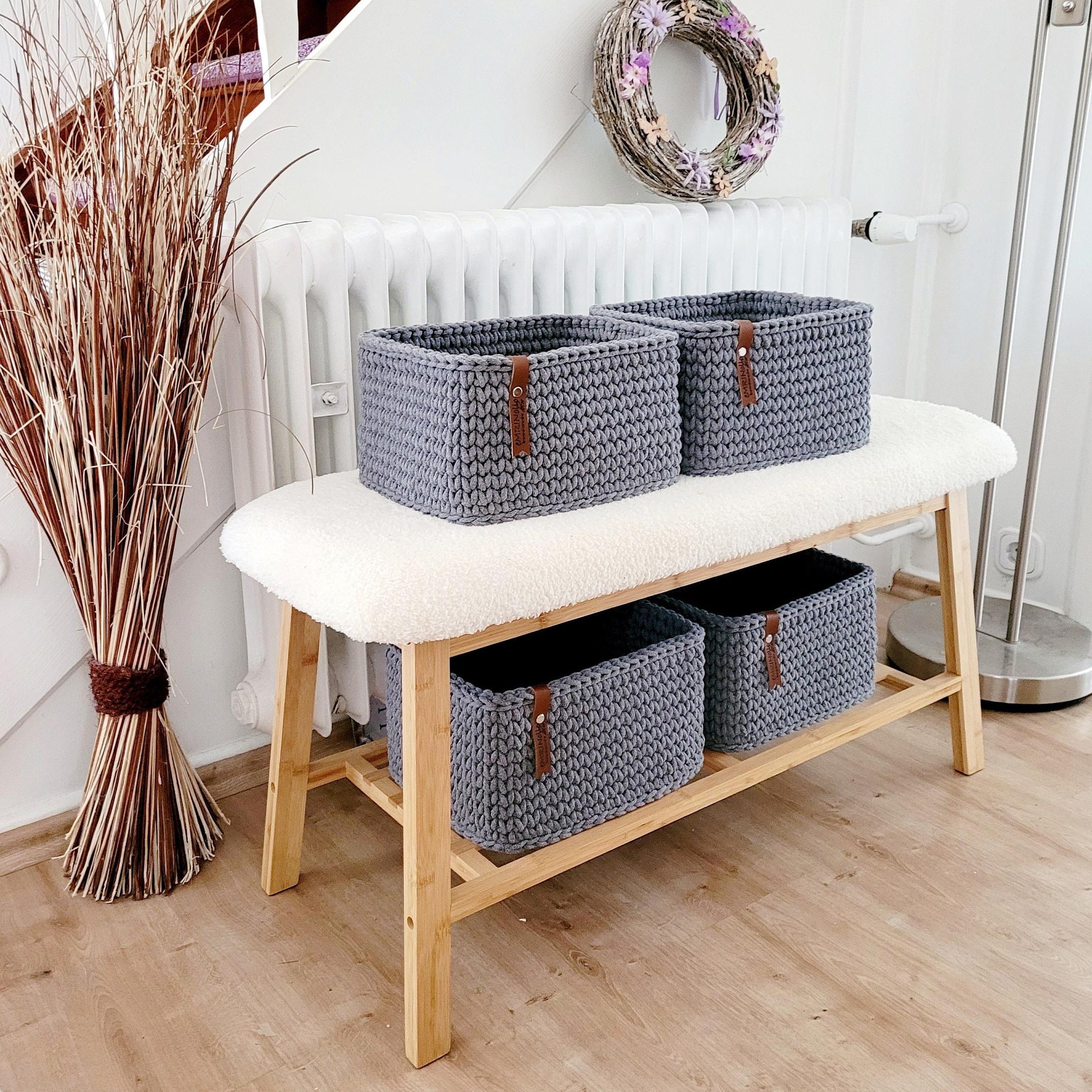 Korb gefüllt mit Handtüchern im Badezimmer auf Holzbank, natürliche Boho-Dekoration.
