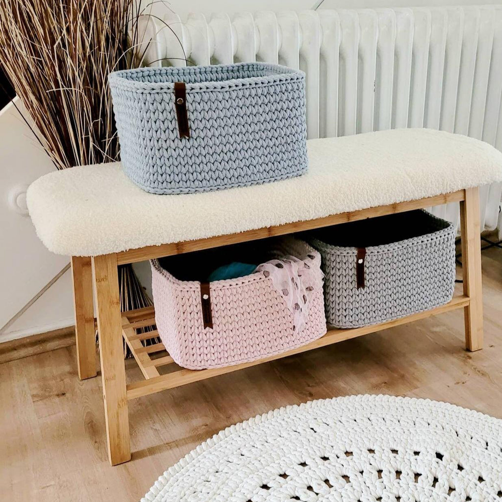 Korb gefüllt mit Handtüchern im Badezimmer auf Holzbank, natürliche Boho-Dekoration.