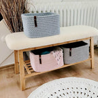 Korb gefüllt mit Handtüchern im Badezimmer auf Holzbank, natürliche Boho-Dekoration.