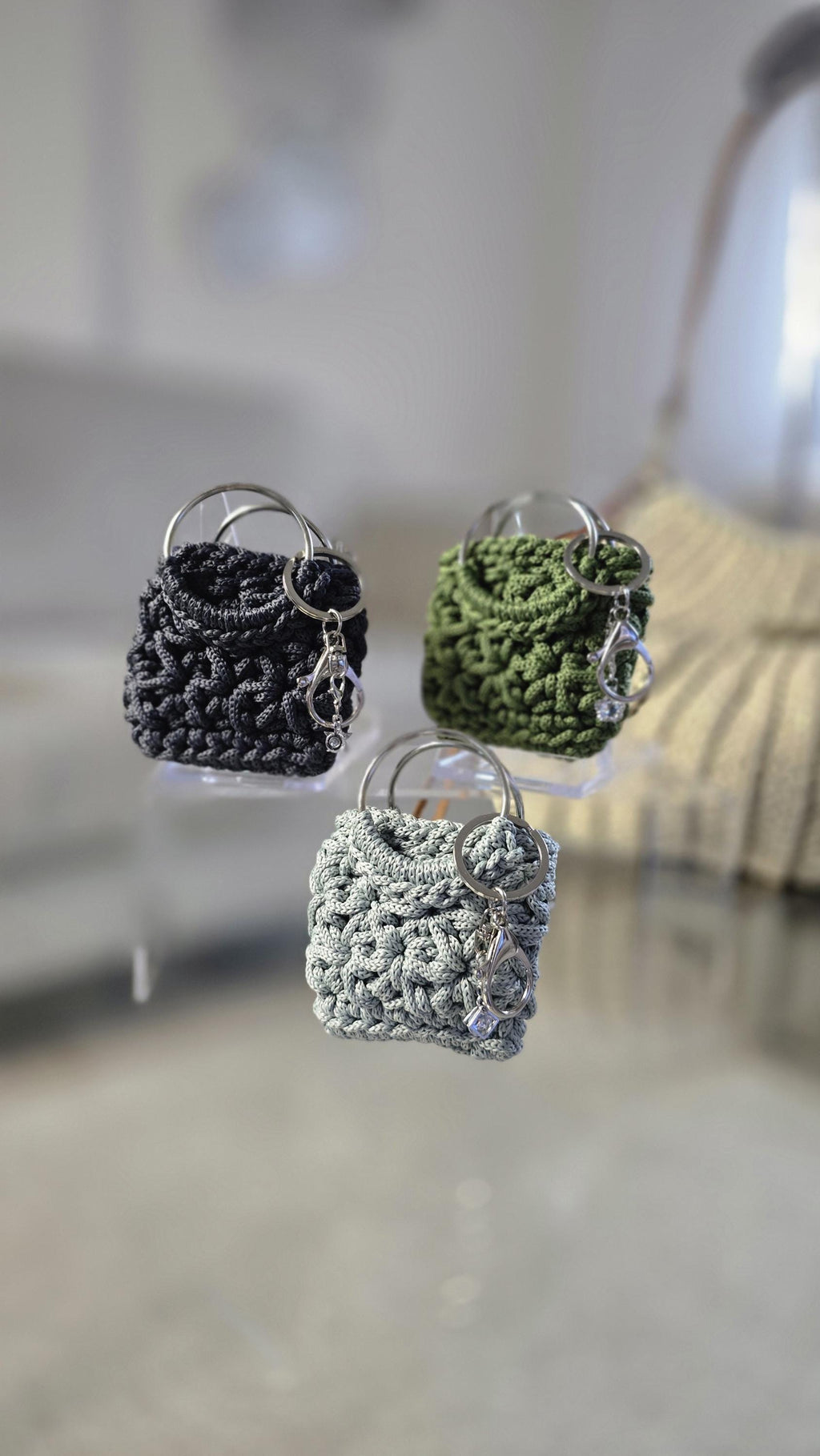 Nahaufnahme der Ringgriffe mit beweglichem Schmuckanhänger am eckigen Accessoire.
