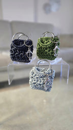 Bag Charm mit zwei großen Metallringen und kleinem Schmuckanhänger in moderner Farbwelt.
