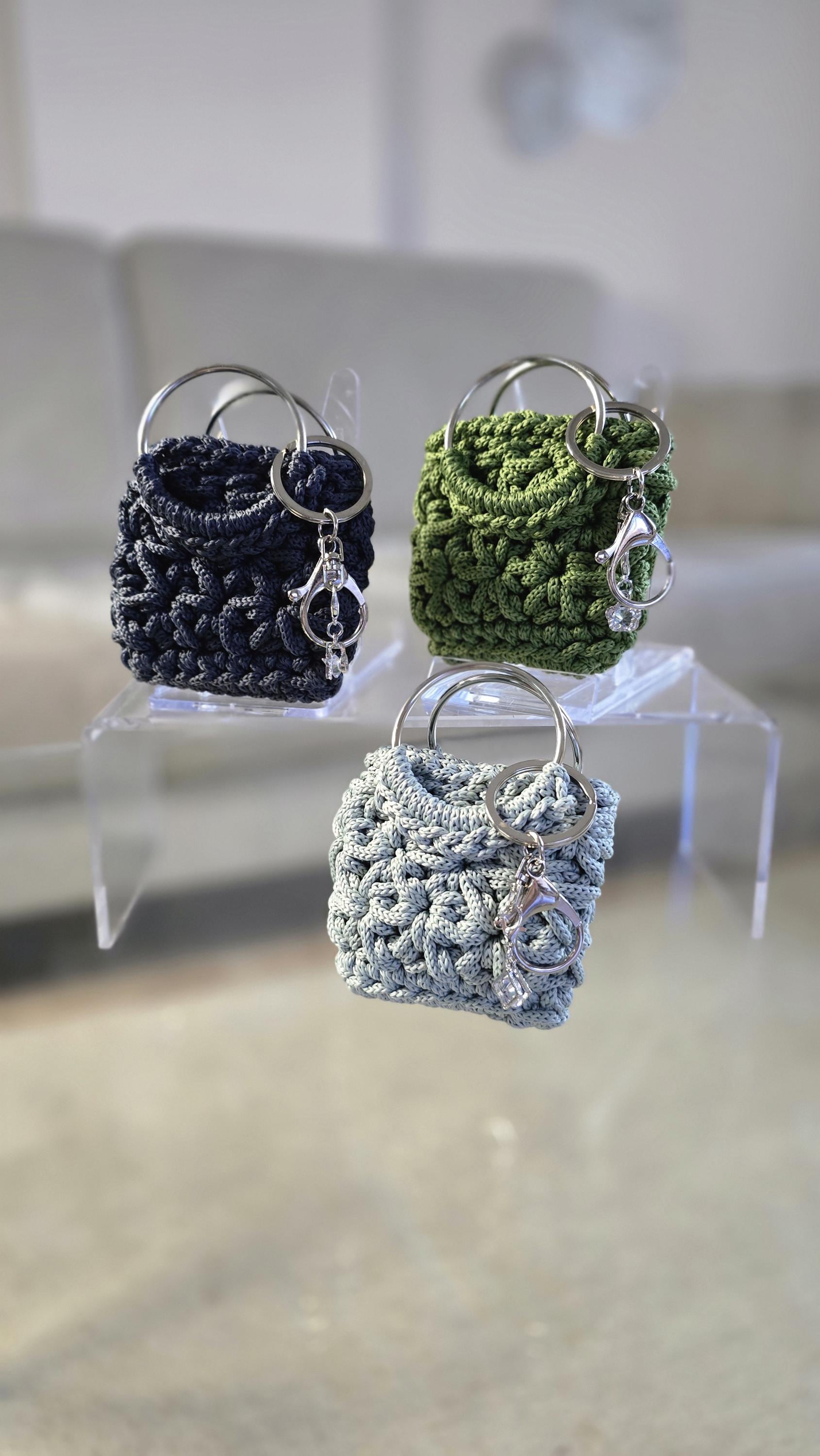 Bag Charm mit zwei großen Metallringen und kleinem Schmuckanhänger in moderner Farbwelt.