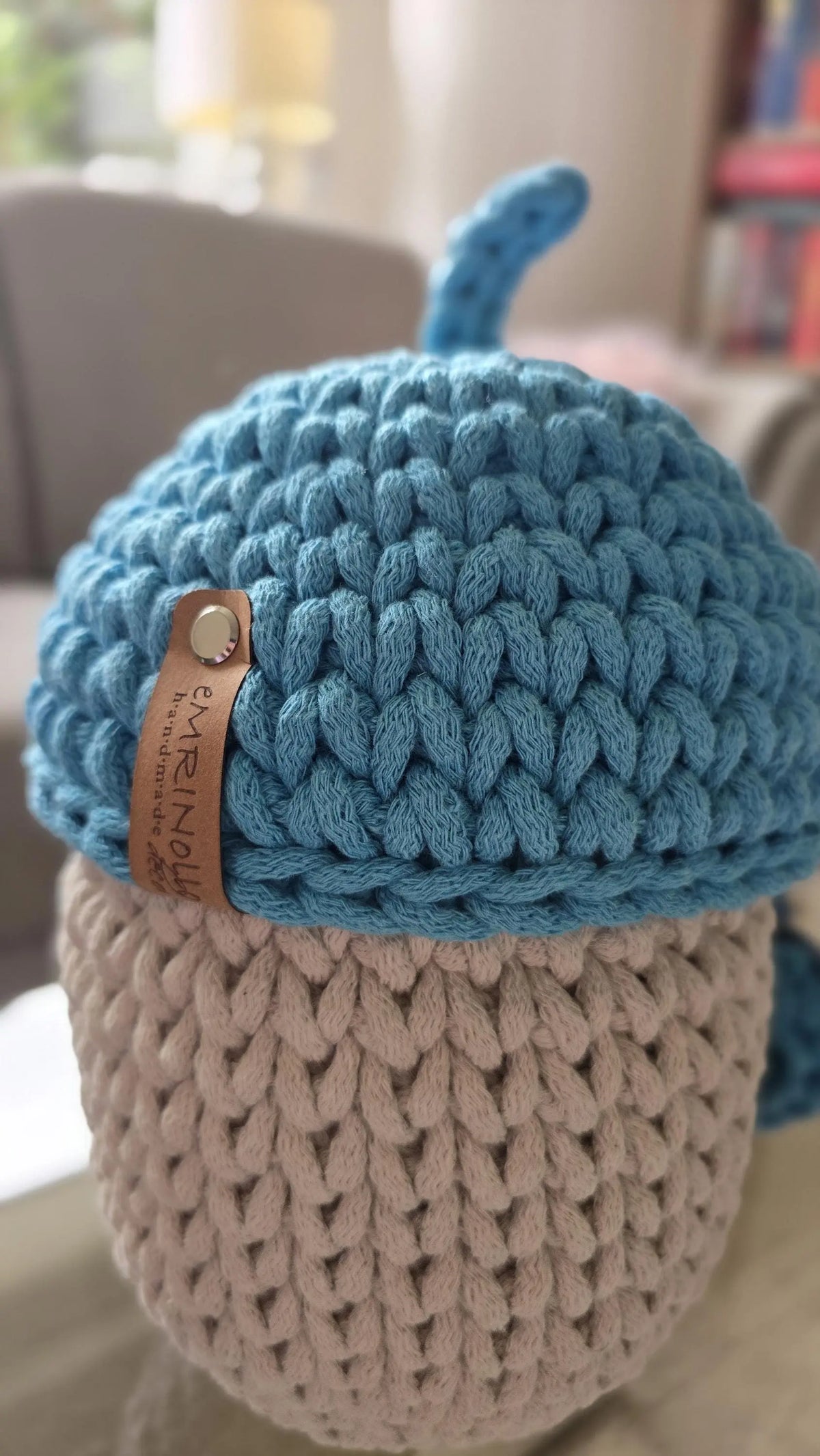 Der Eichelkorb als herbstliche Dekoration auf einem Wohnzimmerregal, kombiniert mit Trockenblumen und Boho-Accessoires.