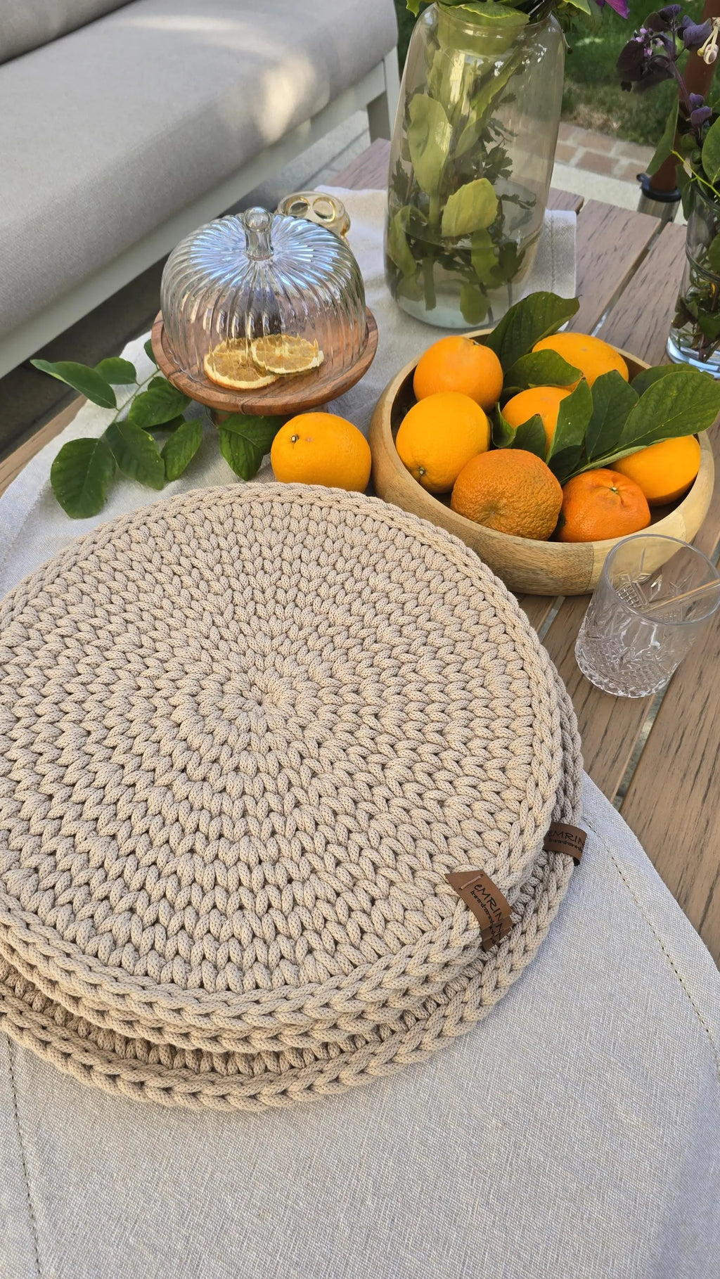 Schrägansicht eines gedeckten Esstischs im skandinavischen Design, auf dem die gehäkelten Unterlagen als gemütliches Boho-Wohnaccessoire dienen.