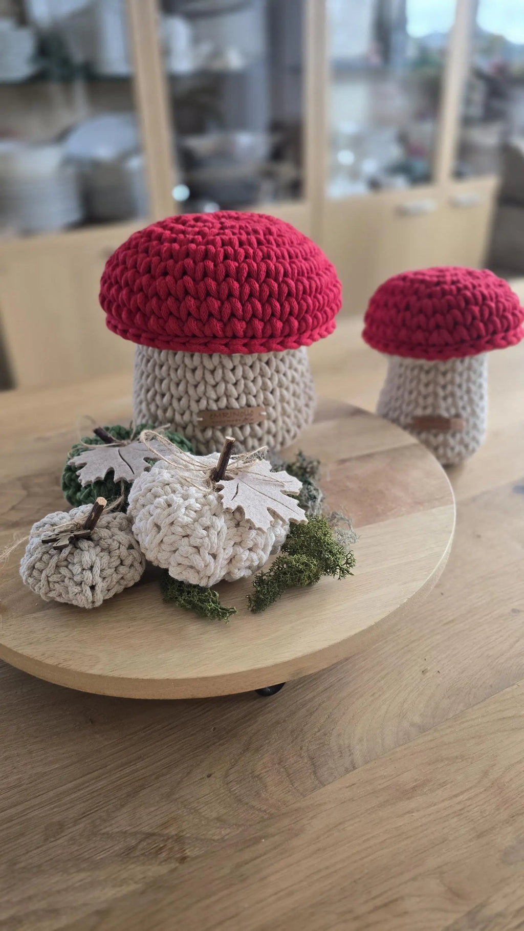 Zwei handgefertigte Pilzkörbchen aus dicker Kordel mit altrosa Kappen in den Größen S und M nebeneinander arrangiert auf einem hellen Holztisch im Kinderzimmer.